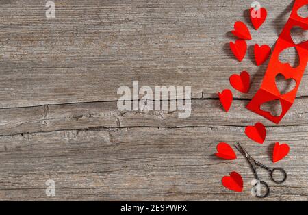 Valentines Day card. Red hearts and scissors on wooden background Stock Photo