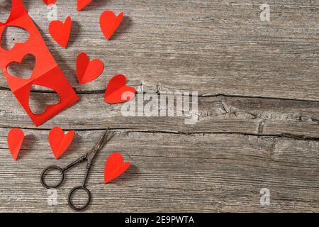 Valentines Day. Red hearts and scissors on rustic wooden background Stock Photo