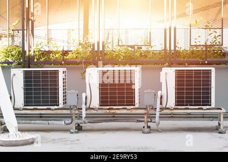 Air condition compressor outdoor unit installed at rooftop of business building with sunlight hot summer season Stock Photo
