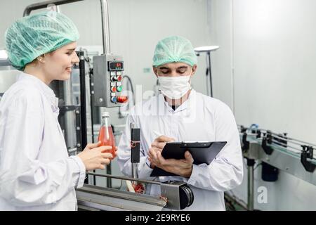 Food and drink factory ISO audit quality control team working, hygiene check and process standard inspection in plant production line. Stock Photo