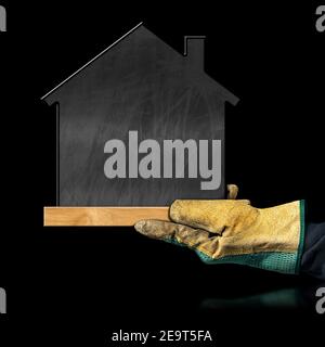 Hand with protective work glove showing a blank chalkboard in the shape of a small house, isolated on black background with copy space.