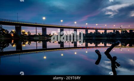 The reflections of the melbourne city skyline at dusk in the still water of the west gate bridge Stock Photo