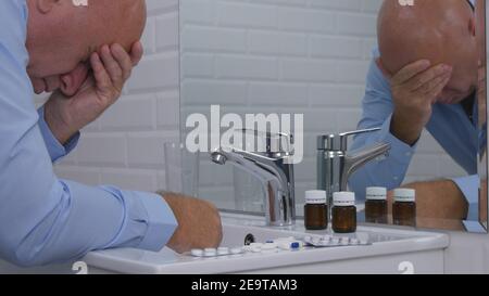 Upset Disillusioned and Disappointed Man in Bathroom Suffering Big Pain Take Pills Stock Photo
