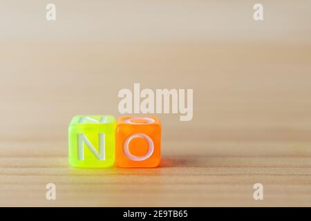 NO text with color letters cubes on wooden background. Minimal concept. Stock Photo