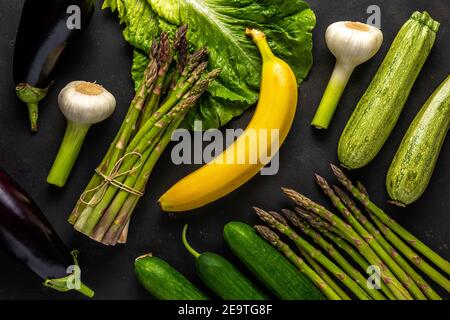 View of fresh asparagus with vegetables on a black table. Food background. Stock Photo