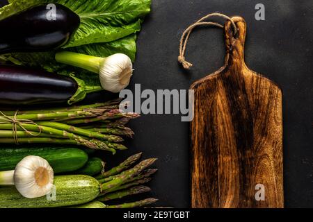 View of fresh asparagus with vegetables on a black table. Food background. Stock Photo