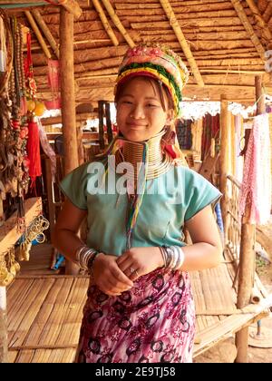 A beautiful smiling Karen hill tribe woman posing in their signature clothes and a unique necklace around her long neck Stock Photo