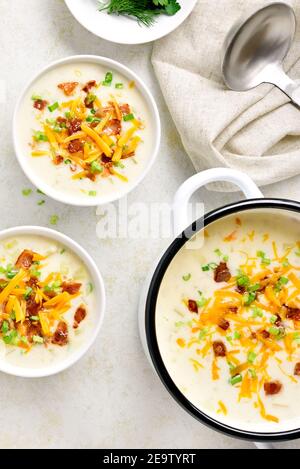 Potato creamy soup with bacon and cheddar cheese on light stone background. Healthy diet dish for dinner. Top view, flat lay Stock Photo