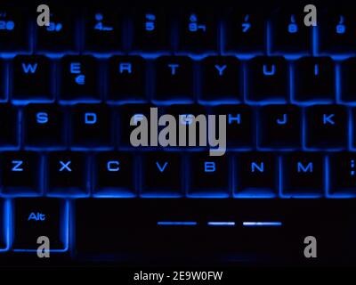 Close up of black keyboard with blue retro light. Stock Photo