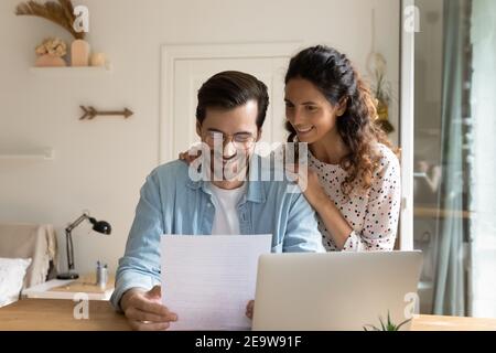 Glad married couple impressed with perfect news received by mail Stock Photo