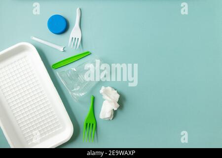 Various plastic trash on blue background, waste sorting and recycling concept, top view Stock Photo