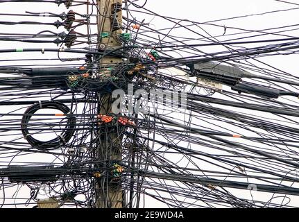 Mass of electric cable wiring on pole, Bangkok, Thailand, South East Asia. Stock Photo