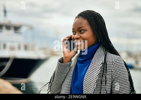 Young african american businesswoman smiling happy talking on the smartphone at the port. Stock Photo