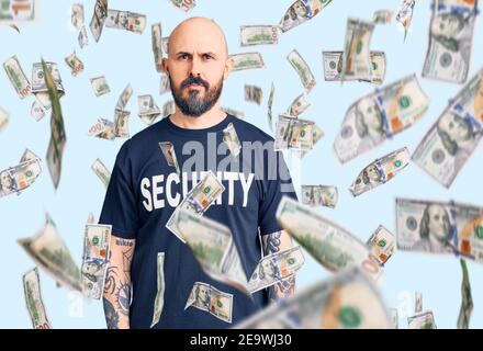 Young handsome man wearing security t shirt relaxed with serious expression on face. simple and natural looking at the camera. Stock Photo