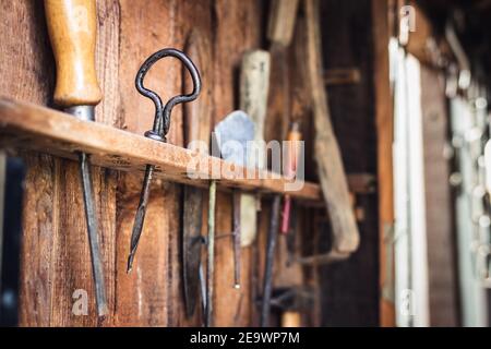 Vintage work tool in carpentry workshop. Hand drill, chisel and other tools on wooden background. Selective focus Stock Photo
