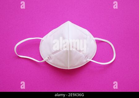 KN95 or N95 FFP2 mask for protection pm 2.5 and corona virus (COVID-19). Anti pollution mask.air face mask, N95 FFP2 mask on pink background. Stock Photo