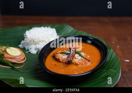 indian Fish Curry with rice served on banana leaf,