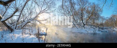 Frosty winter panoramic landscape with forest river during sunny january morning.