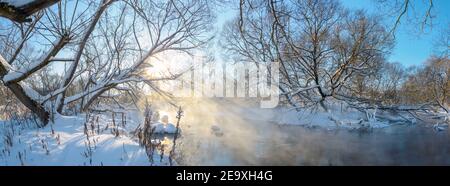 Frosty winter panoramic landscape with forest river during sunny january morning. Stock Photo