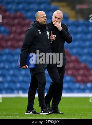 Burnley manager Sean Dyche chats with his assistants on the touchline ...