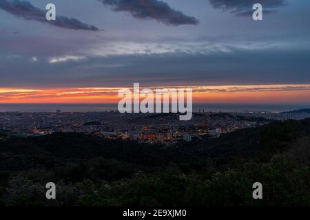 Sunrise on a spring day in the city of Barcelona. We can see the sky, with some clouds that light up like fire, with the sunlight. Mediterranean Sea. Stock Photo