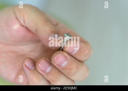 foreman's working hand holds a screw close-up. Stock Photo