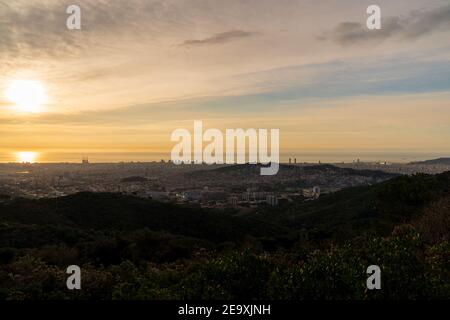 Sunrise on a spring day in the city of Barcelona. We can see the sky, with some clouds that light up like fire, with the sunlight. Mediterranean Sea. Stock Photo