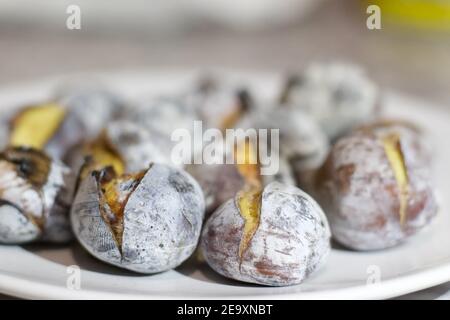 Roasted chestnuts on white plate Stock Photo