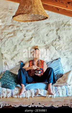 Blond man practicing meditation at home Stock Photo