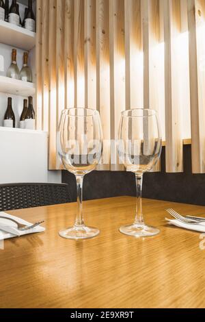 Fragile empty goblets standing on wooden table Stock Photo
