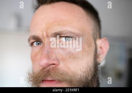 Hipster man with beard looking at camera and with face with movie makeup Stock Photo