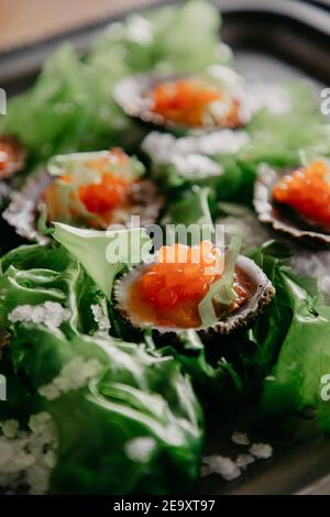 From above delicatessen exquisite oysters in shells with sea salt seaweed and caviar Stock Photo