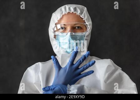 Nurse in personal protective equipment (PPE), doctor wearing medical glasses and face mask, portrait of woman in professional suit due to COVID-19 cor Stock Photo