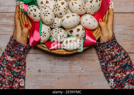 Happy Easter. Woman Hands holding basket with hand made decorated Easter eggs.Spring decoration background. Festive tradition for Europe Stock Photo
