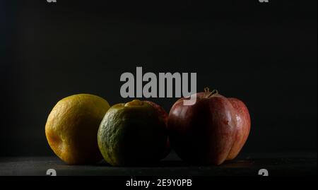 Apples and oranges in black background Stock Photo
