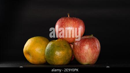 Apples and oranges arranged in black background Stock Photo