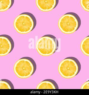 Pattern made of lemon slices on pink background, tropical citrus fruit Stock Photo