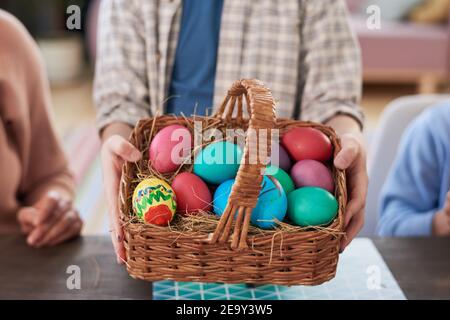 Close-up of child holding basket with colored Easter eggs Stock Photo