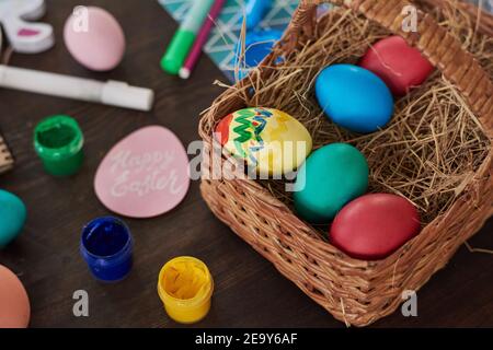 Close-up of basket with Easter painted eggs on the table preparing for holiday Stock Photo