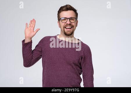 Mature caucasian man saying hello, waving a hand. Welcome home sign Stock Photo