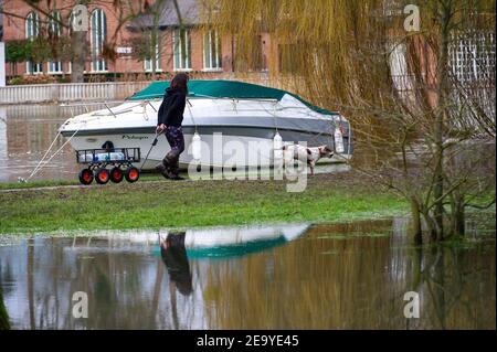 Cookham, Berkshire, UK. 6th February, 2021. A river dweller goes to get some supplies. A Flood Alert remains in force along the stretch of the River Thames from Hurley to Cookham. The Pound across Cookham Moor flooded earlier this week and remains closed to traffic following flooding. The flood water levels have lessened, however, further rain is expected overnight together with possible snow and the Environment Agency are closely monitoring the situation. Credit: Maureen McLean/Alamy Live News Stock Photo