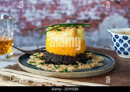 Haggis, neeps and tatties stack (haggis with turnips and potatoes) with whisky sauce - traditional Scottish dish for Burns Night Stock Photo
