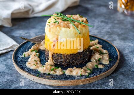 Haggis, neeps and tatties stack (haggis with turnips and potatoes) with whisky sauce - traditional Scottish dish for Burns Night Stock Photo