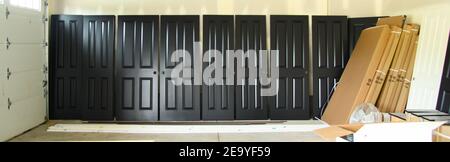 Painted doors for house in new house construction drying after being spray painted black. Stock Photo