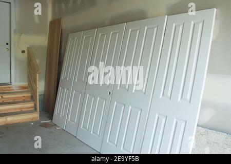 Painted doors for house in new house construction drying after being spray painted white Stock Photo