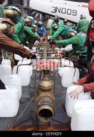 Crew members aboard USS Abraham Lincoln (CVN 72) fill jugs with purified water from a Potable Water Manifold. The Repair Division aboard Lincoln constructed the manifold in eight hours. The water jugs will be flown by Navy helicopters to regions isolated by the Tsunami in Sumatra, Indonesia. Helicopters assigned to Carrier Air Wing Two (CVW-2) and Sailors from Abraham Lincoln are supporting Operation Unified Assistance, the humanitarian operation effort in the wake of the Tsunami that struck South East Asia. Photo by Seth C. Peterson/USN via ABACA. Stock Photo