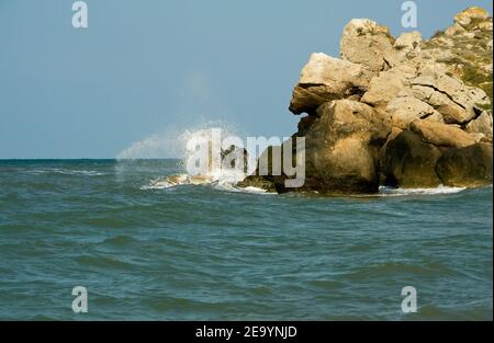 Sea waves break into small splashes on the rocks. Stock Photo