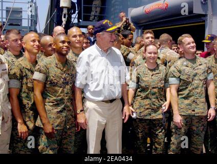 Former President George H. W. Bush is flanked by Marines while posing for a photo aboard the amphibious dock landing ship USS Fort McHenry (LSD 43). Sailors and Marines greeted former President Bill Clinton and George H. W. Bush as they toured Sri Lanka, Thailand and Indonesia to see first hand, the effects the tsunami had on Southeast Asia on February 20, 2005. Photo Michael D. Kennedy/USN via ABACA. Stock Photo