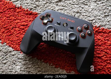 Black and red macro game controller on red line background. Gaming joystick for computer and console closeup. Button and analog on futuristic gamepad Stock Photo