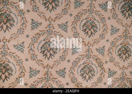Close-up of a carpet texture with patterns in the form of a floral ornament. Stock Photo